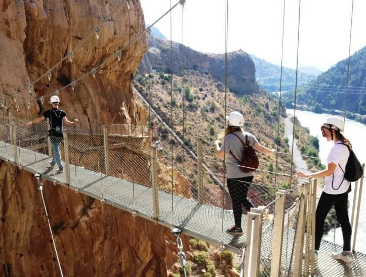 Walkers crossing the Caminito del Rey suspension bridge high above a gorge