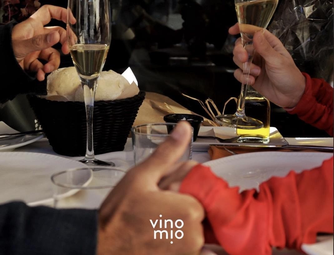 Guests raising glasses of cava over bread at a restaurant table